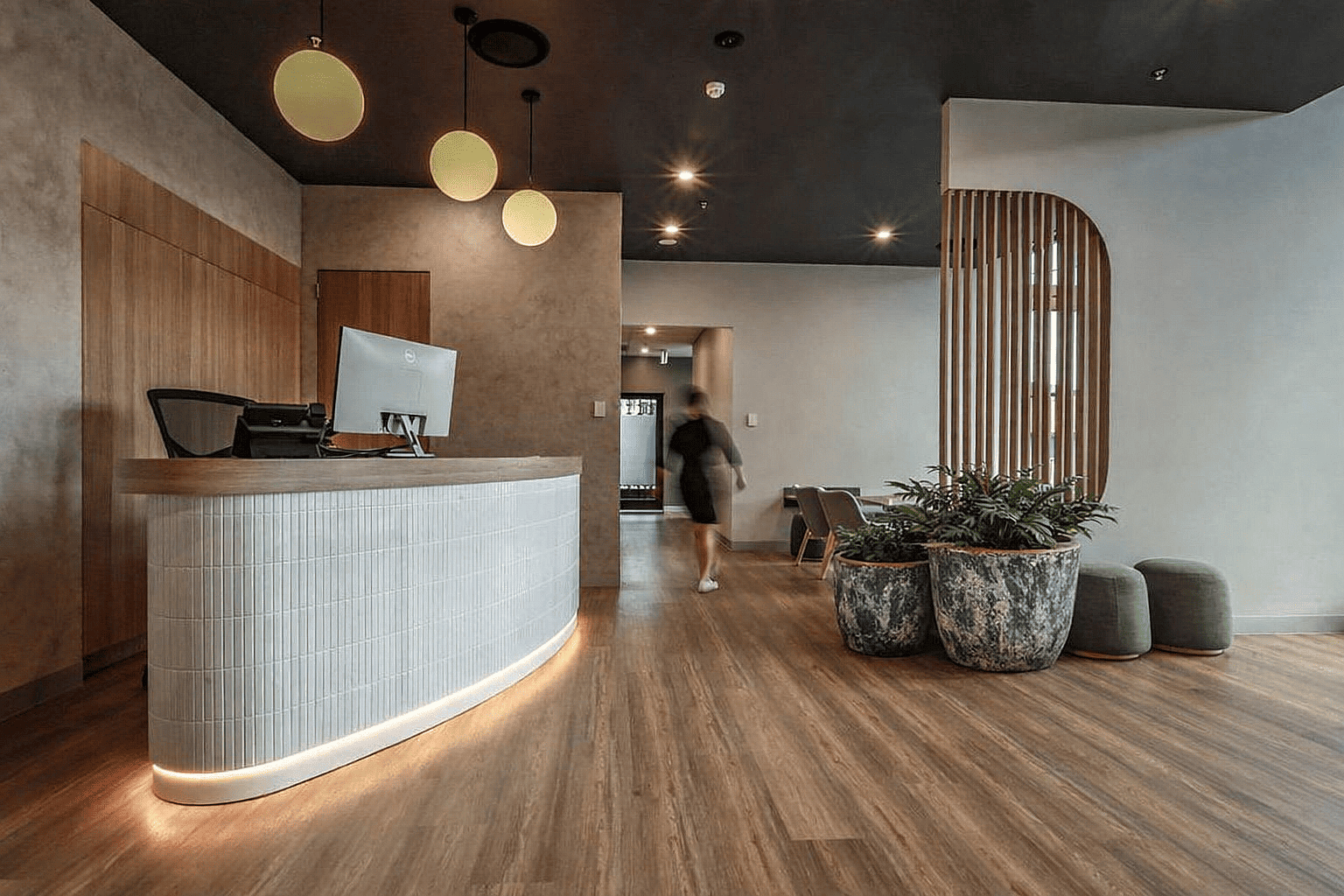 Large distressed ceramic planters with indoor greenery placed in the reception area of a modern healthcare clinic